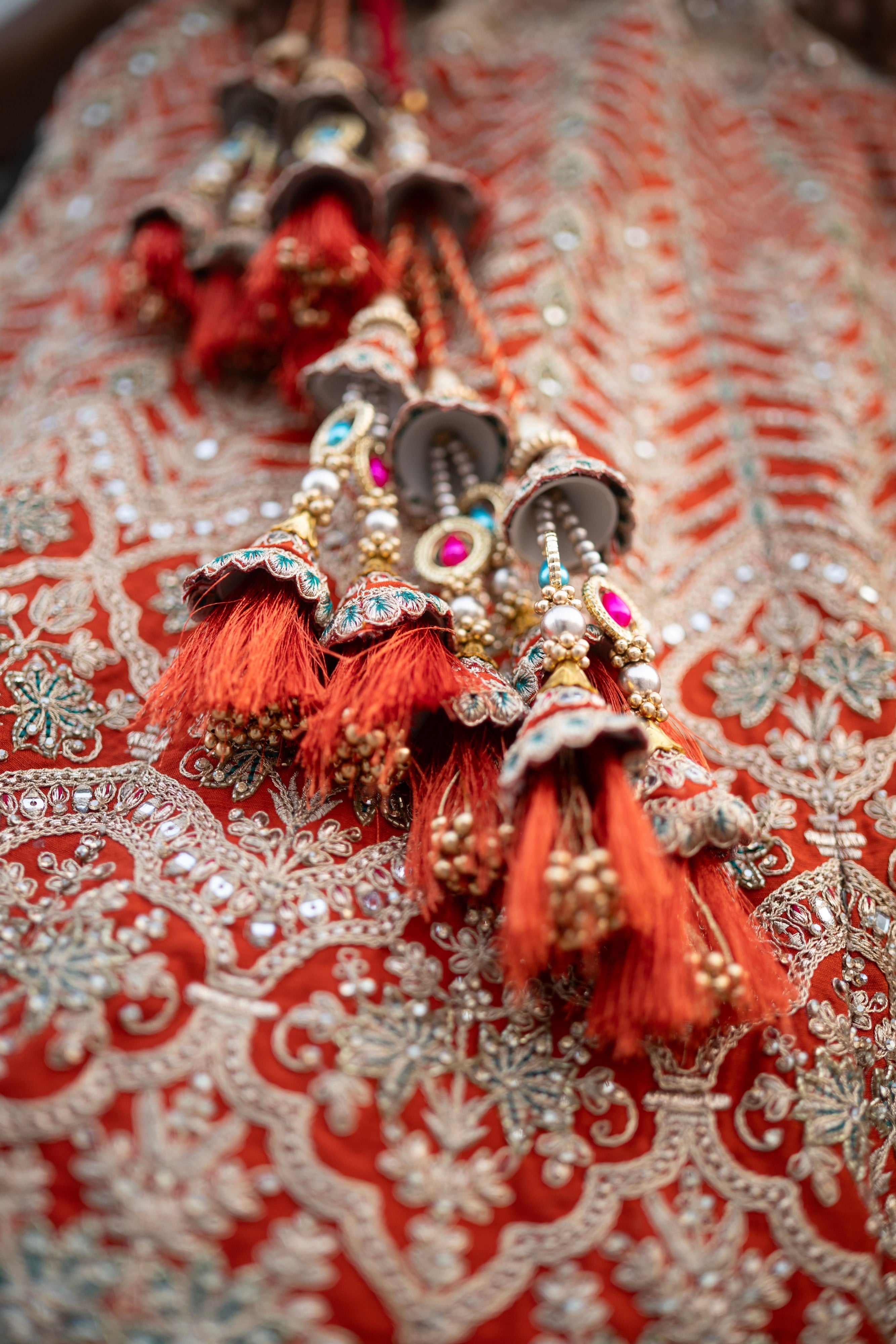 Red and gold embroidery and tasselled latkans on a bridal lehenga