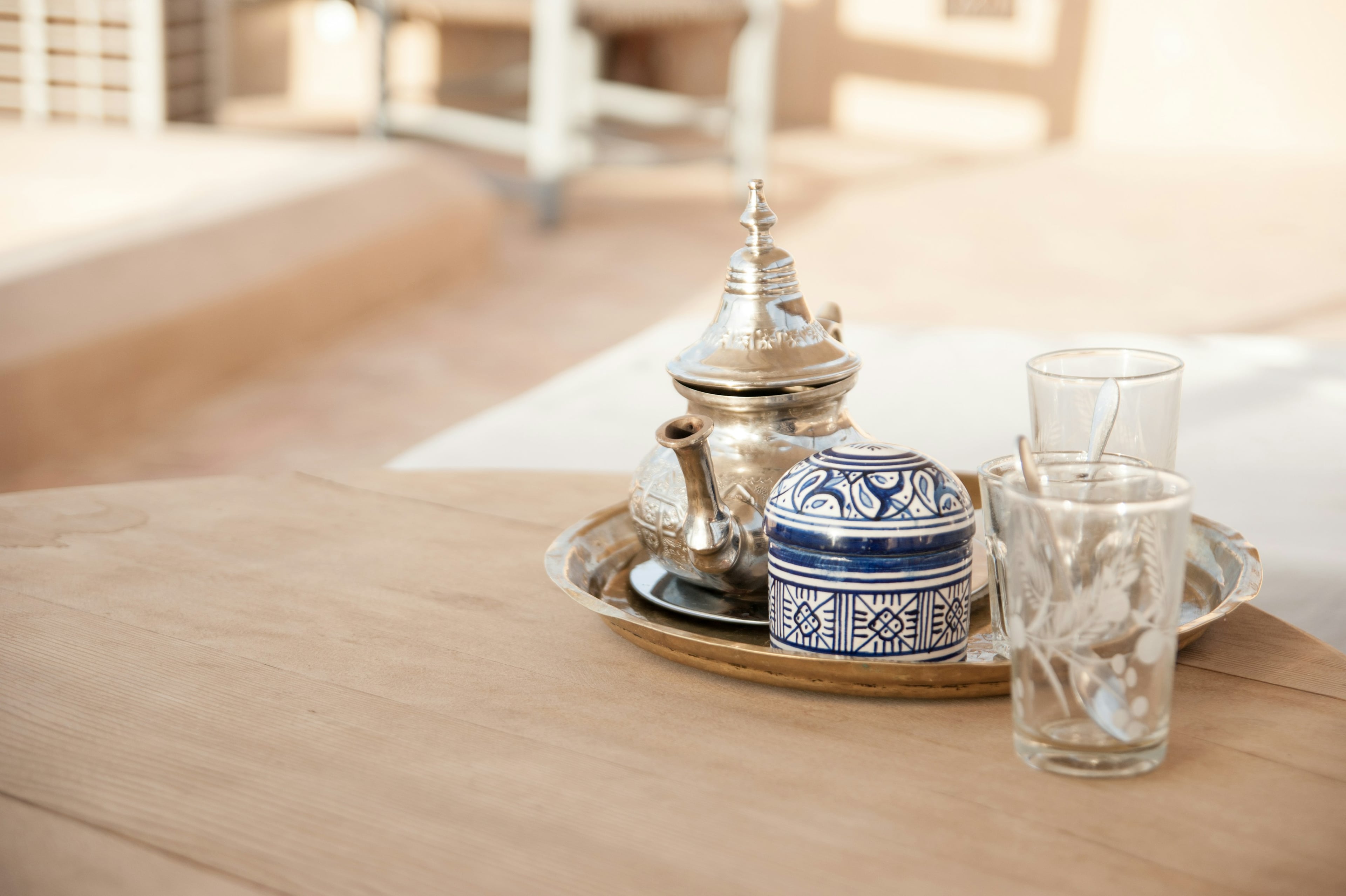 A silver teapot, a sugar bowl and tea glasses on a tray