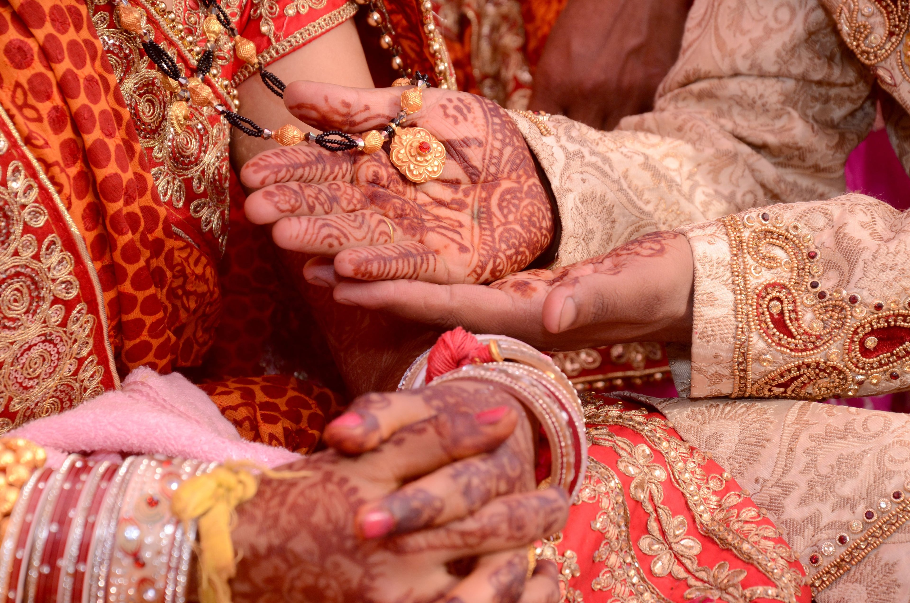 A bride’s and a groom’s hands, painted with henna, joined during the ceremony